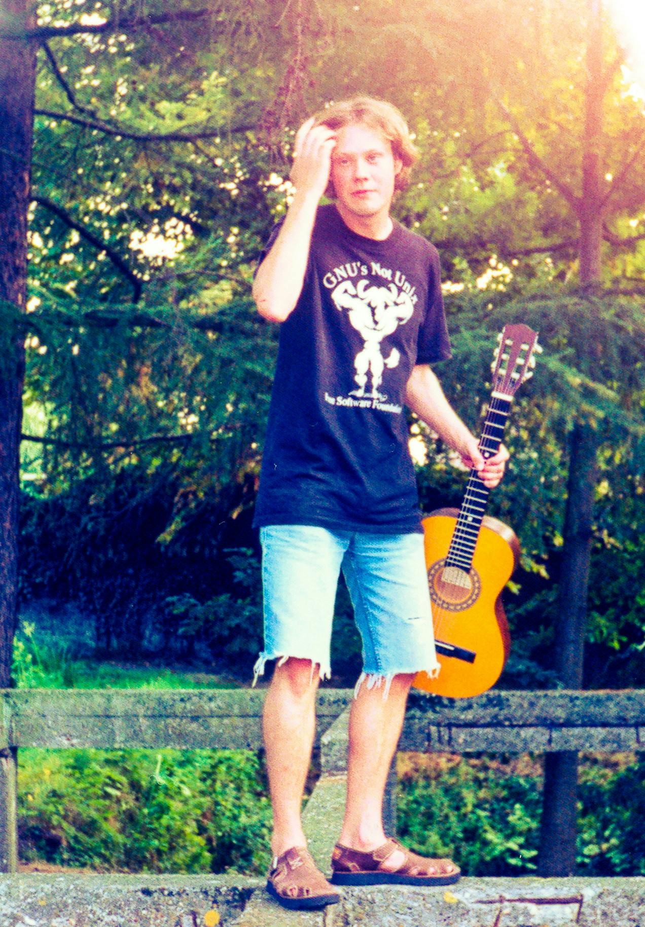 Philippe wearing his signature T-shirt, guitar in hand